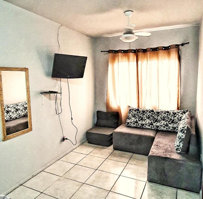 uma sala de estar com um sofá e uma janela em Apto Jk em Cachoeirinha em Cachoeirinha