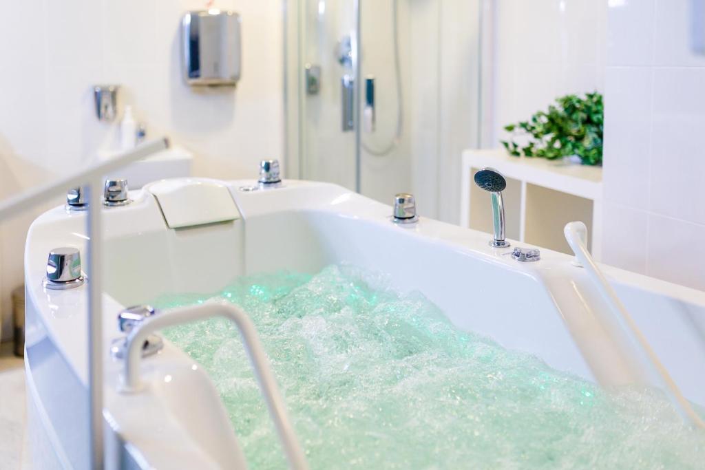 a bath tub with water in a bathroom at Hotel Thermal in Karlovy Vary