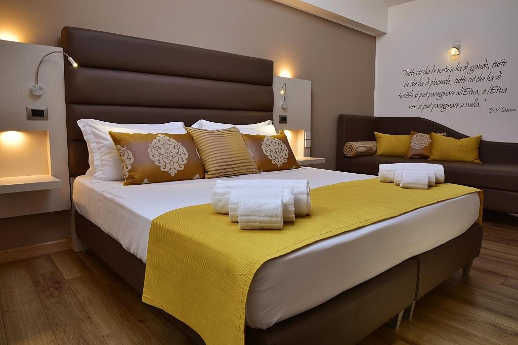 a bedroom with a large bed with a yellow blanket at Palazzo Sisto Exclusive Rooms in Catania