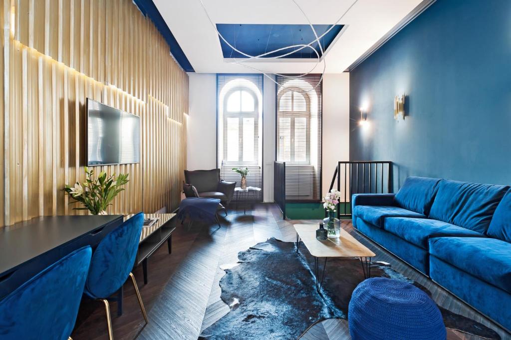 a living room with a blue couch and a table at House of LoftAffair in Krakow
