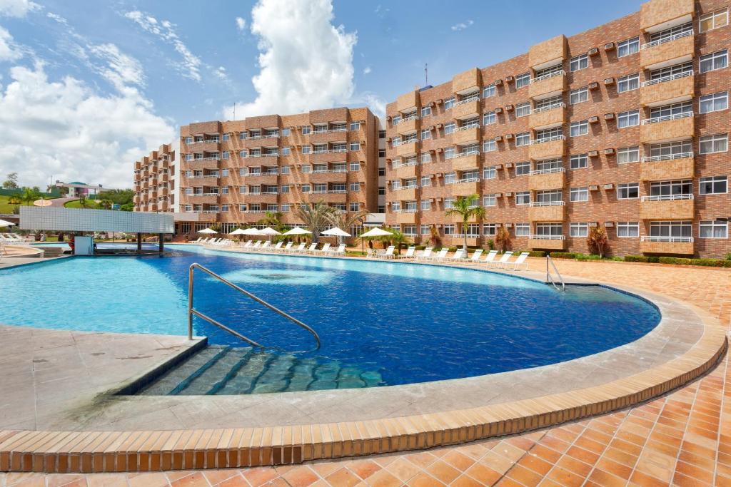 a large swimming pool in front of a building at Hotel - Gran Lençóis Flat in Barreirinhas