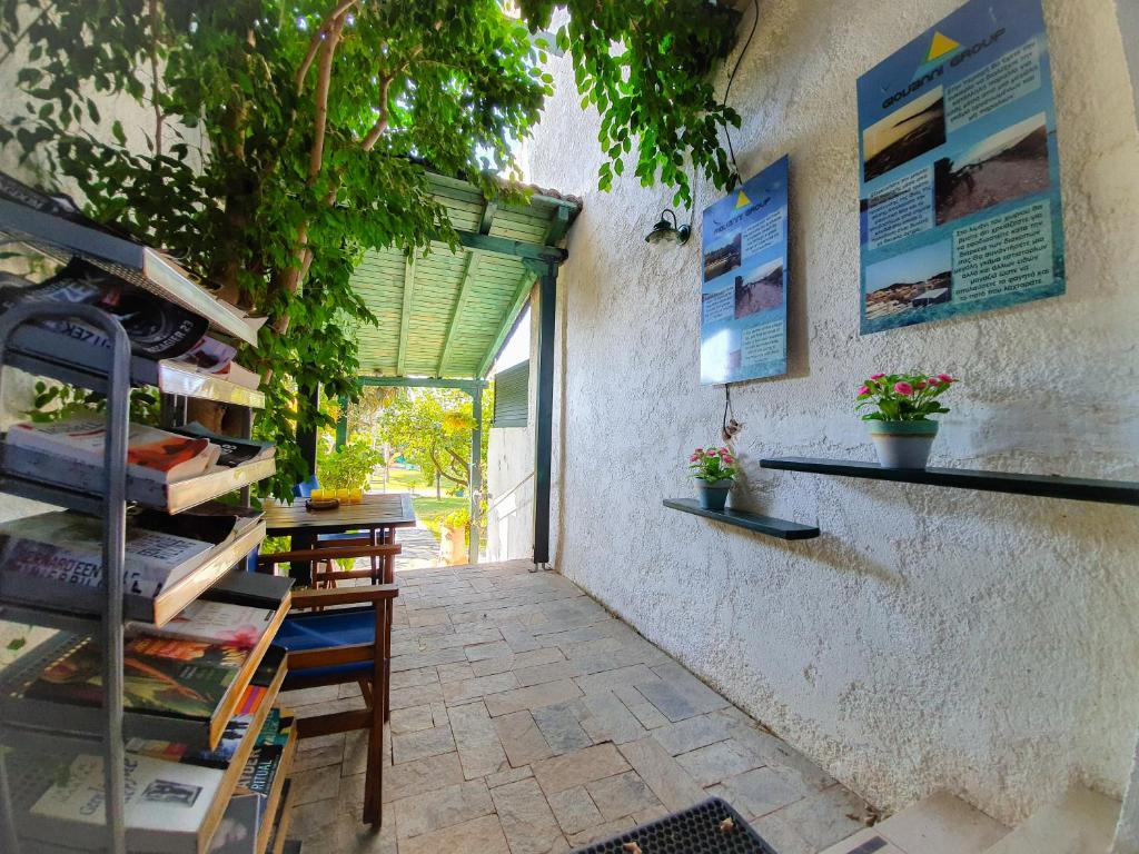 a room with a table with books on a wall at Giovanni Group Apartments in Syvota