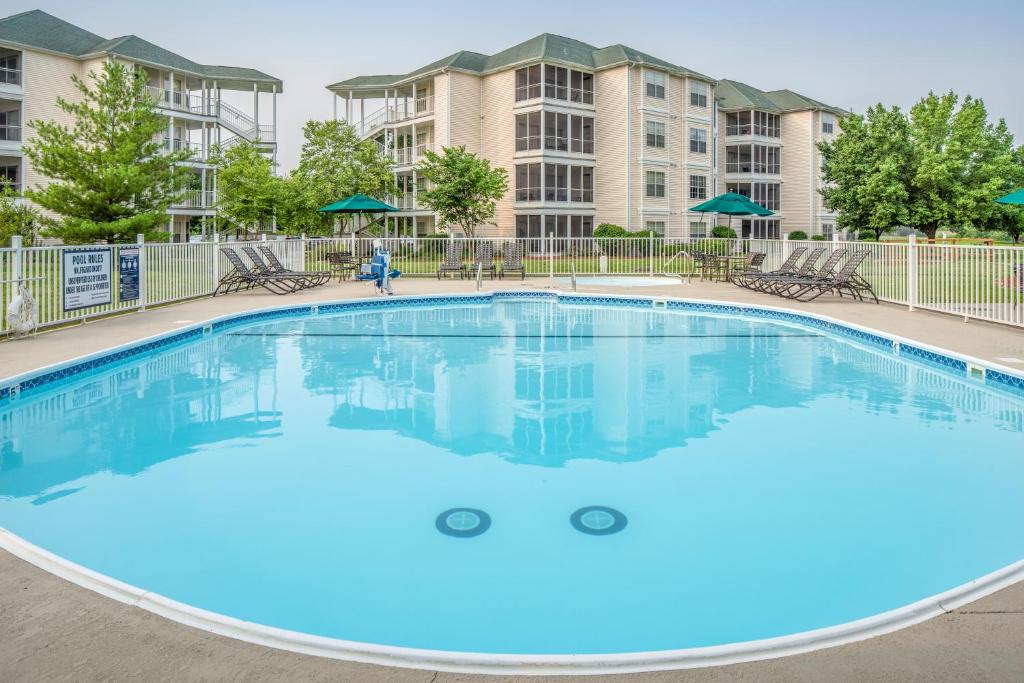 une grande piscine d'eau bleue en face des condos dans l'établissement The Suites at Fall Creek, à Branson