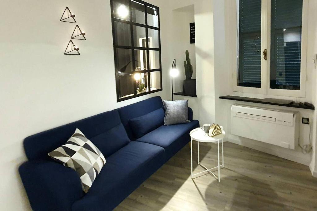 ein Wohnzimmer mit einem blauen Sofa und einem Tisch in der Unterkunft ALTIDO Heart of the City 1 Bed Apt near Castle Belvedere in Genua