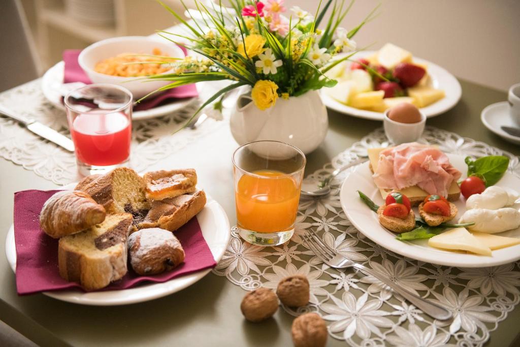 a table topped with plates of breakfast foods and orange juice at Palazzo Indelli in Monopoli