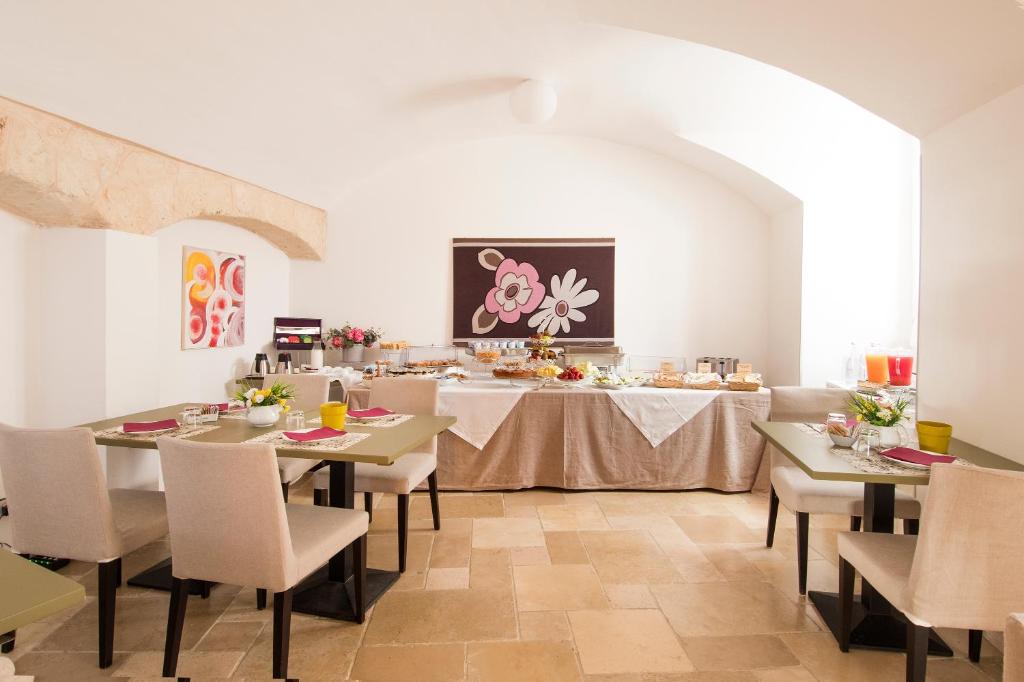 a dining room with tables and chairs and a table with a table at Palazzo Indelli in Monopoli