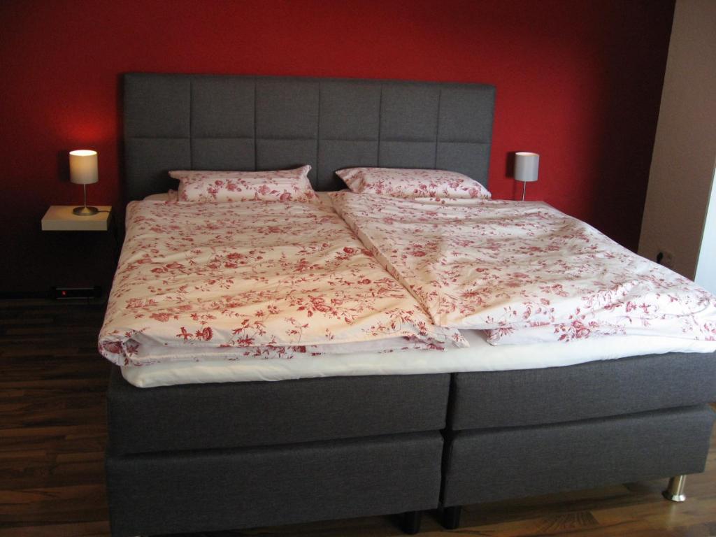 ein Schlafzimmer mit einem großen Bett mit rosa Bettwäsche und Kissen in der Unterkunft Willkommen zuhause! Welcome home! in Koblenz