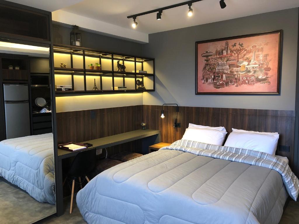 sypialnia z 2 łóżkami i biurkiem w obiekcie Apartamento super bem decorado em frente ao shopping w mieście Kurytyba