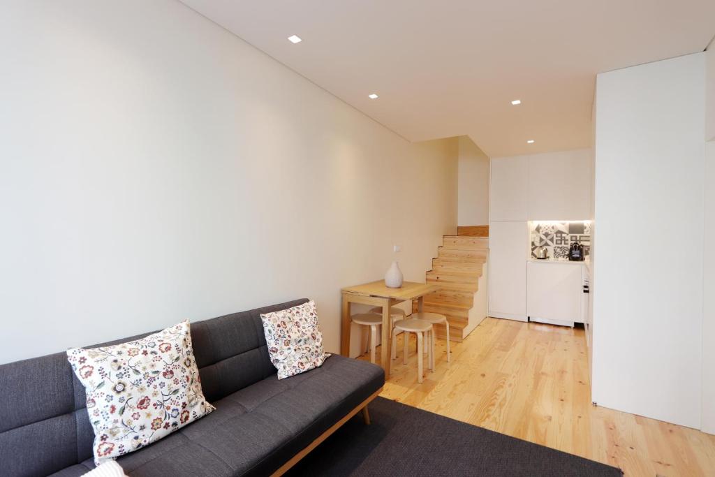 un soggiorno con divano e tavolo di HM - Charming Pinheiro Duplex Apartment a Porto