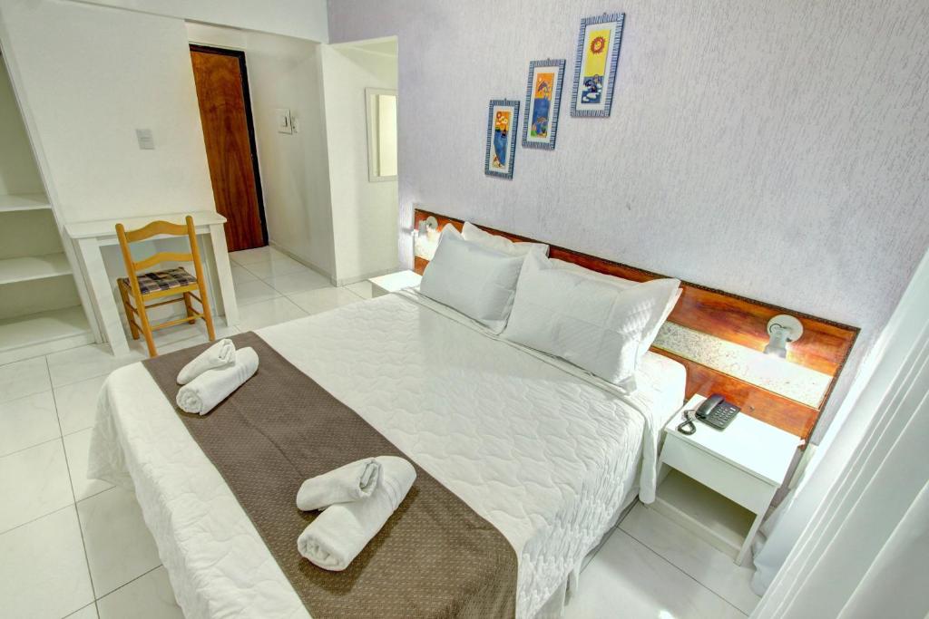 a bedroom with a large bed with towels on it at Hotel Praiamar in Balneário Camboriú