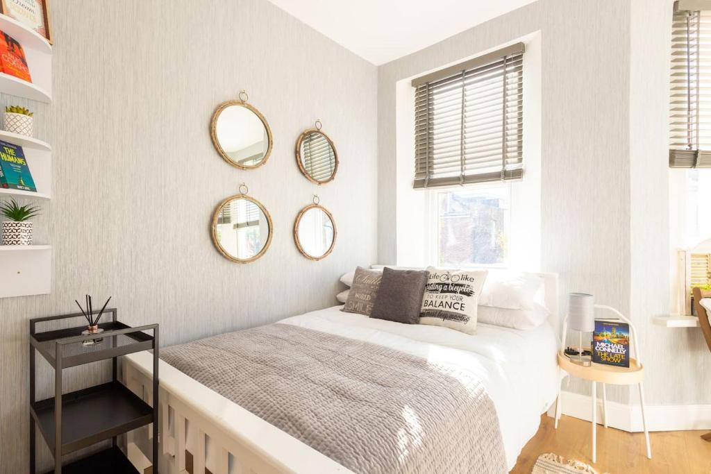 a bedroom with a bed and mirrors on the wall at Lovely Studio Flat in West Kilburn by Queen's Park in London