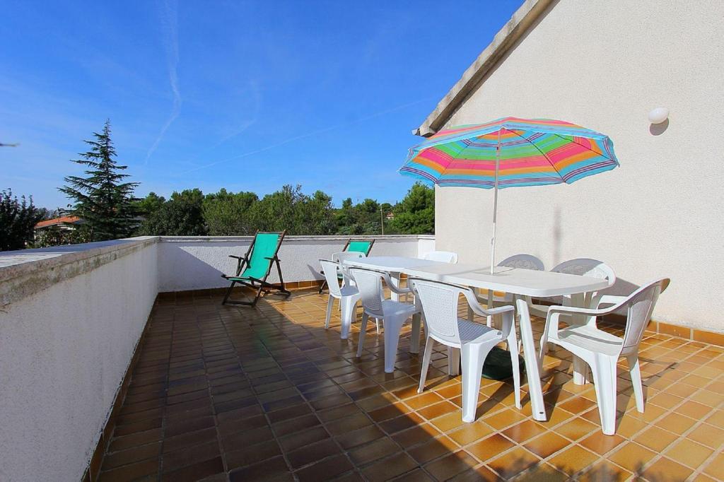 a patio with a table and chairs and an umbrella at Apartment Jovanka in Medulin