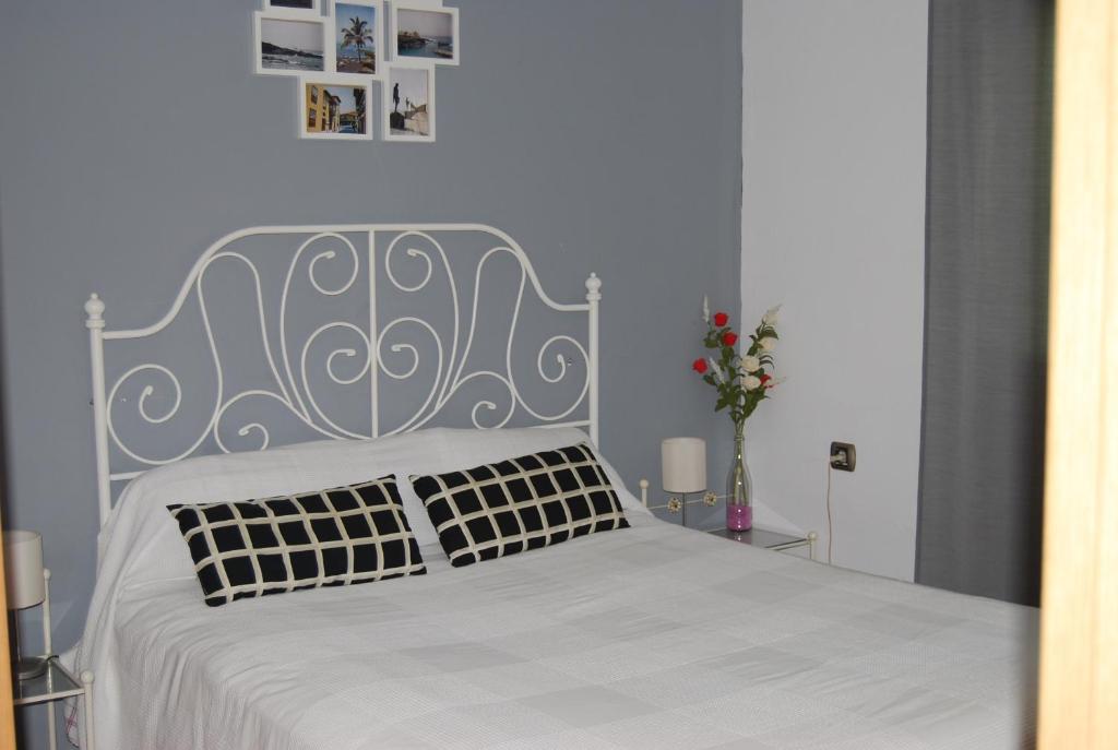 een slaapkamer met een wit bed met 2 kussens bij Vivienda Rural El Retorno in Sevilla