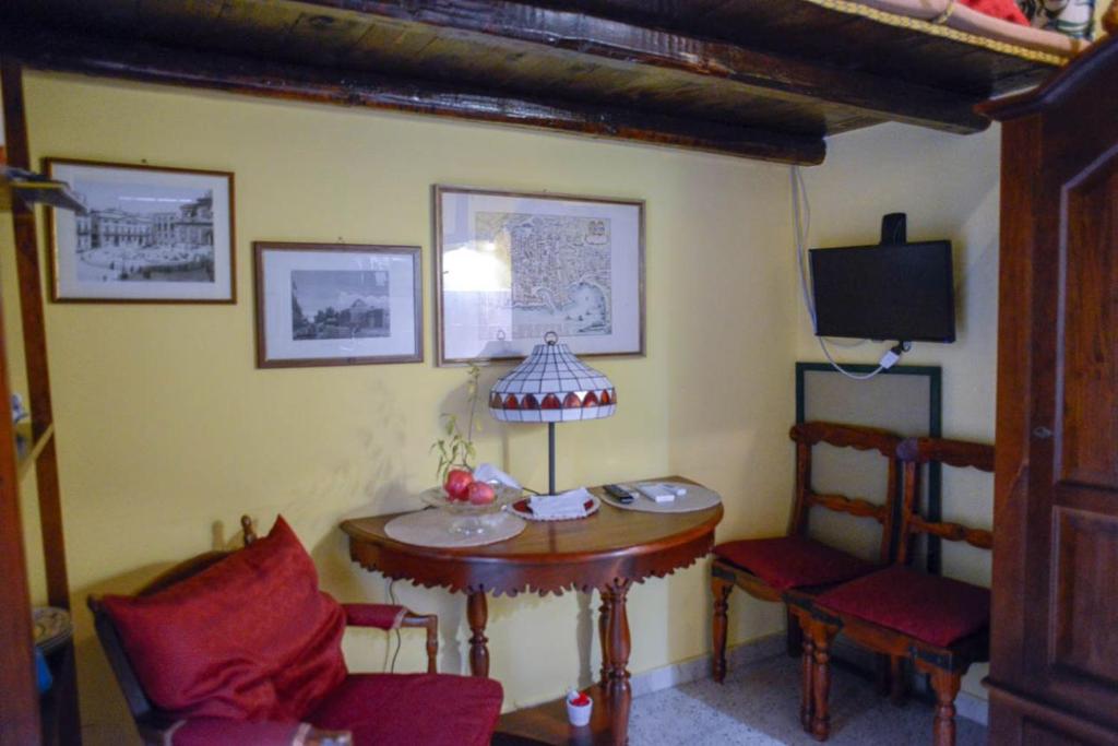 een kamer met een tafel en stoelen en een televisie bij Millimetro in Palermo