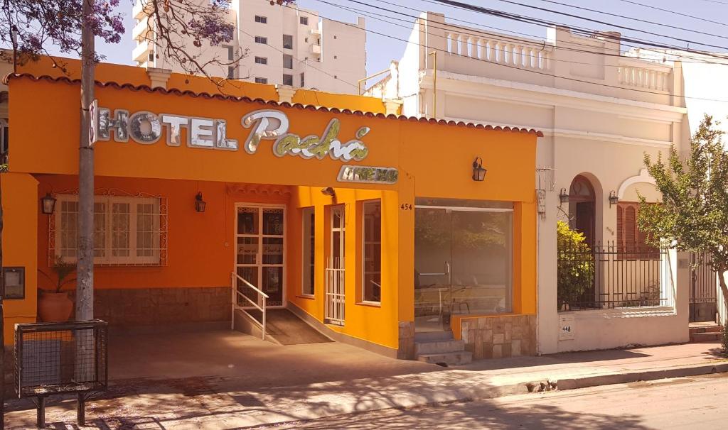 an orange building with a sign on the side of it at Pachá Anexo Rooms in Salta