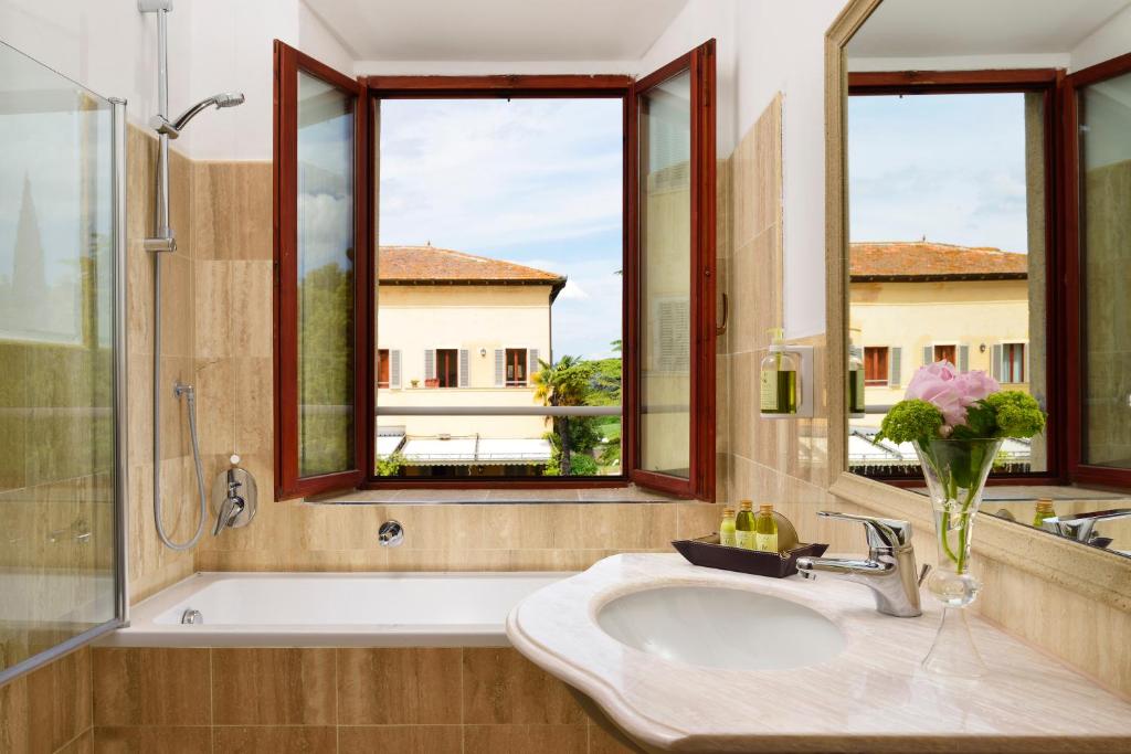 コッレ・ディ・ヴァル・デルザにあるVilla Saboliniのバスルーム(シンク、バスタブ付)、窓2つが備わります。