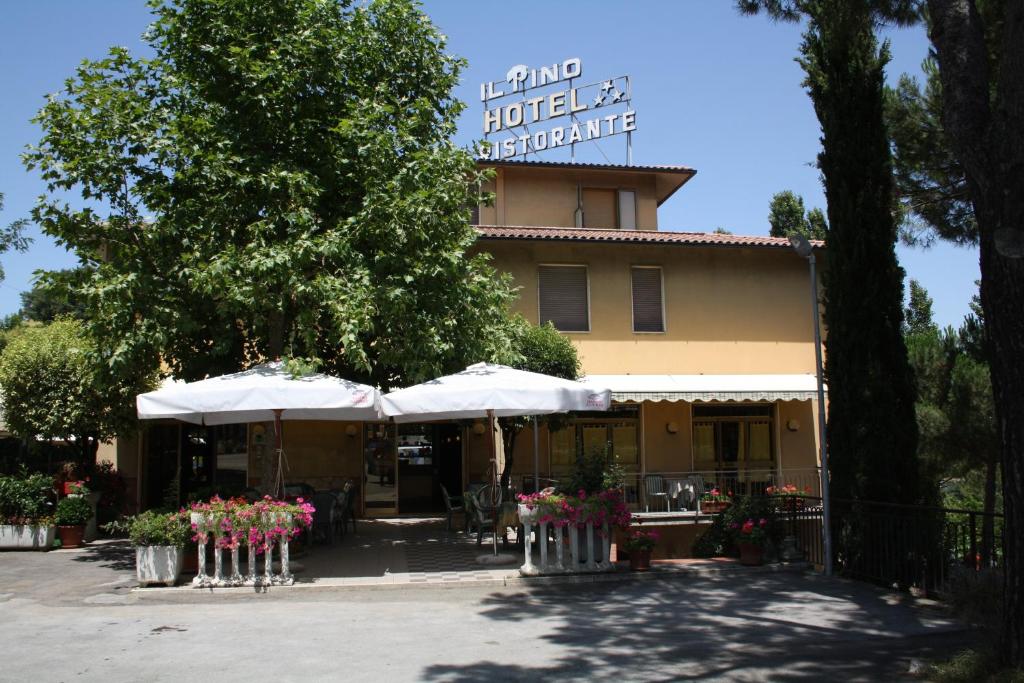 un edificio con sombrillas y flores delante de él en Hotel Ristorante Il Pino, en Chiusi