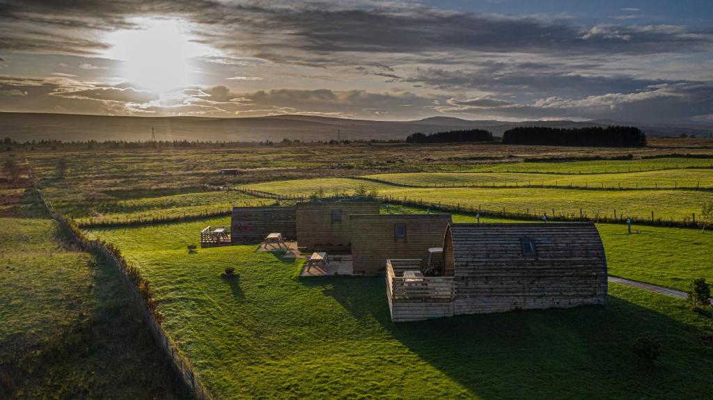 an aerial view of a field with two huts at Loch Shin Glamping Pods in Lairg