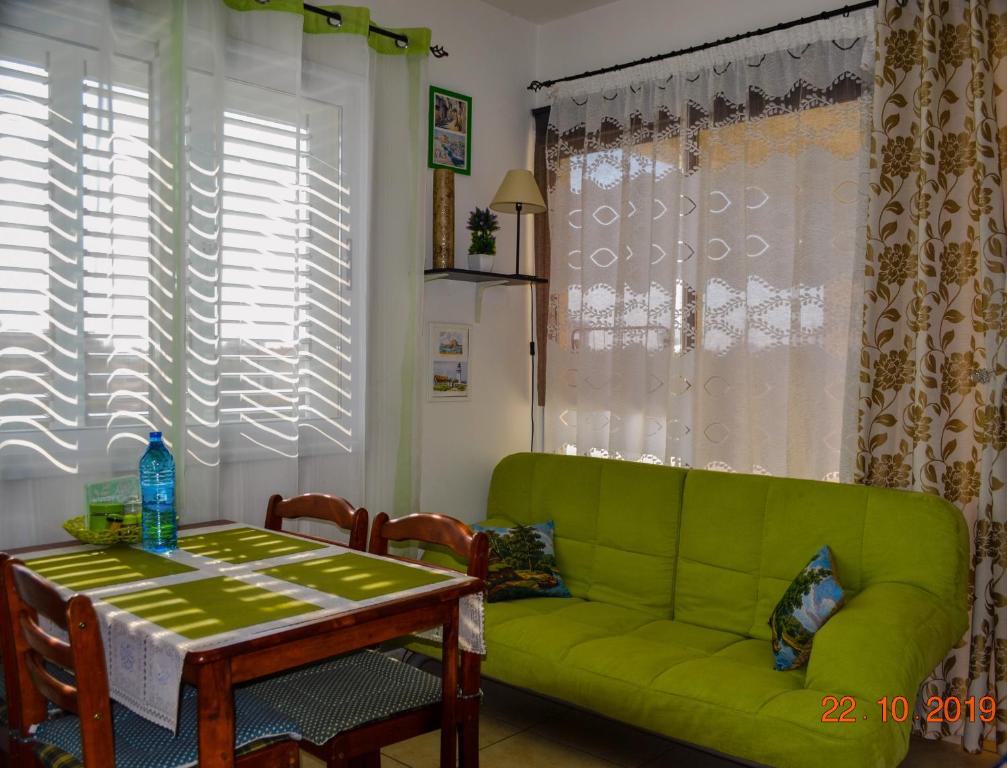 a living room with a green couch and a table at Enjoy the silence apartments in Paphos