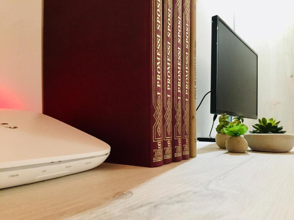 a laptop computer sitting on a desk next to books at Le Déjà Vue in Città di Castello