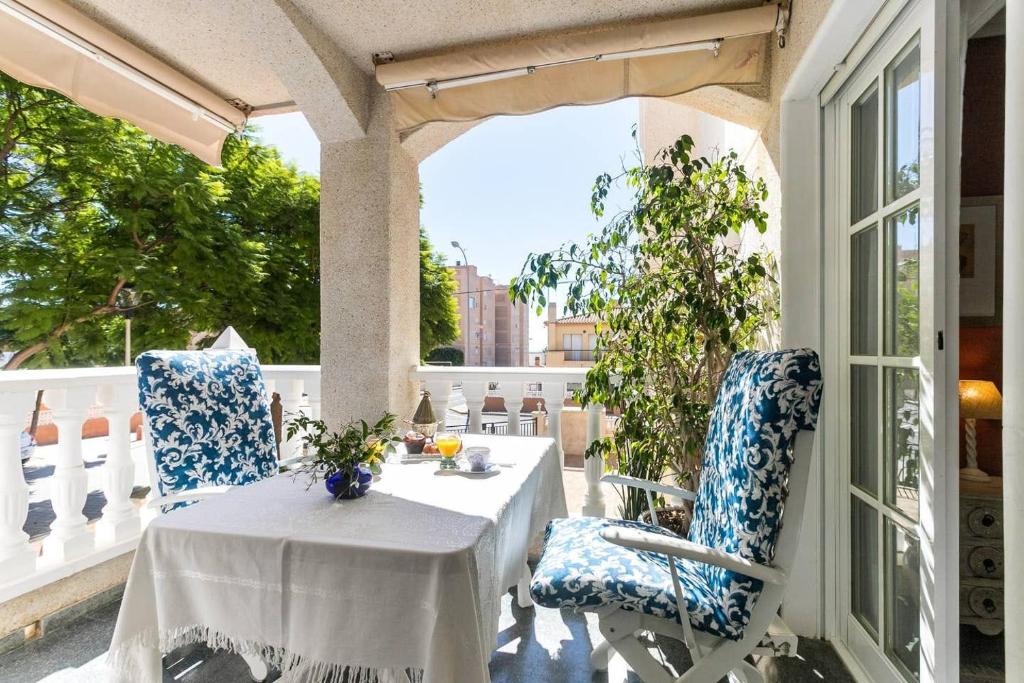 una mesa blanca y sillas en un balcón con mesa y ventana en Fantástico apartamento con piscina, en Santa Pola