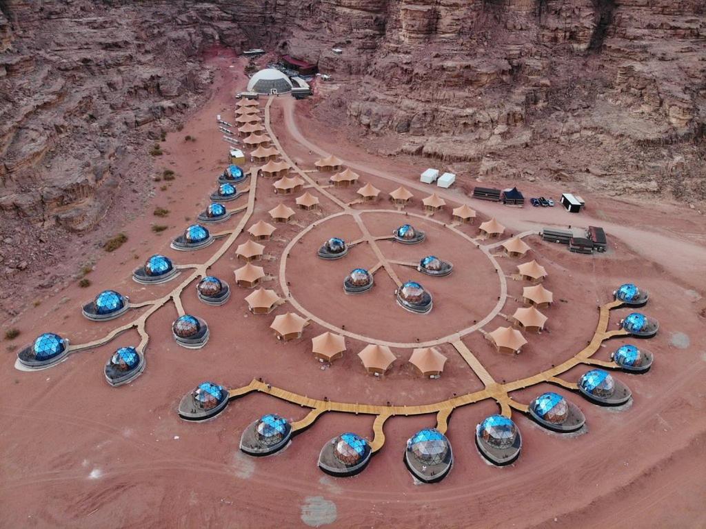 eine Gruppe von Booten, die in der Wüste geparkt sind in der Unterkunft Memories Aicha Luxury Camp in Wadi Rum