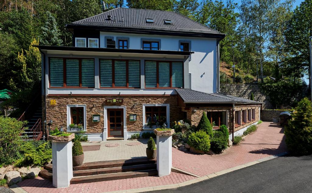 uma casa com uma grande casa com um alpendre em Penzion a restaurace Bílý Mlýn em Liberec