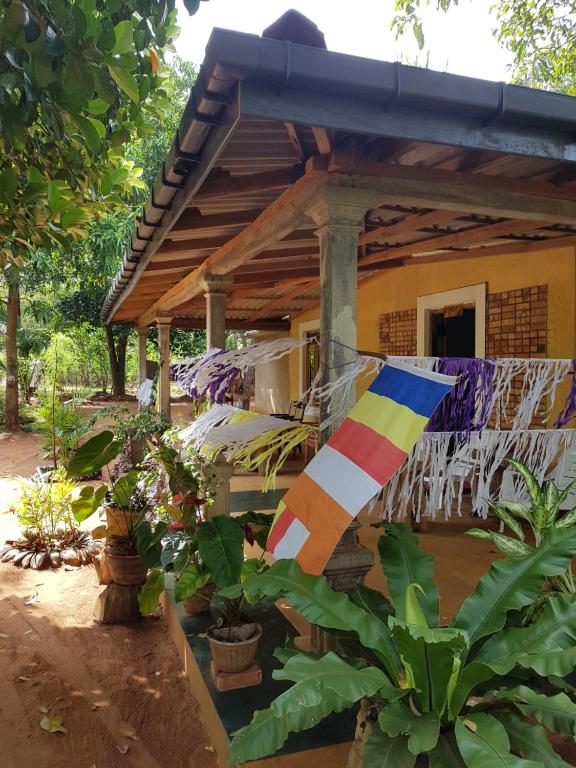 a house with a flag in front of it at Thilina Homestay in Sigiriya