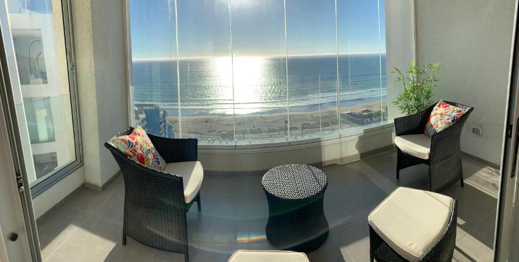 Habitación con sillas y vistas al océano. en Departamento Club Oceano, en Coquimbo