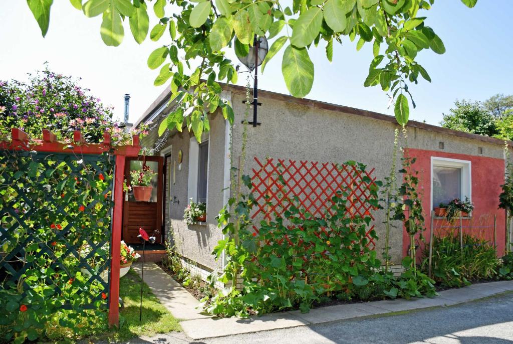 ein Haus mit einem roten Zaun und einem Garten in der Unterkunft Ferienhaus Familie Teetz in Göhren