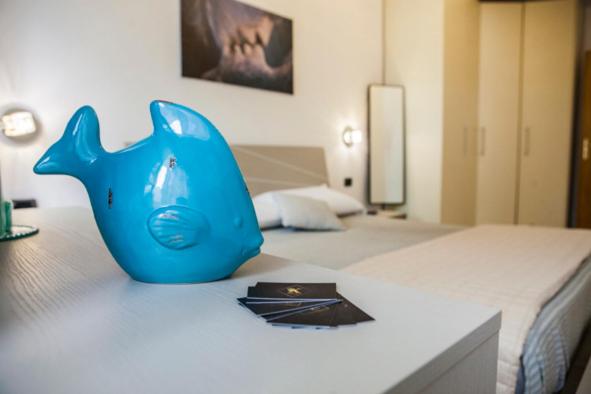Una jarra azul sentada encima de una cama en Casa vacanze Ķ-HOME, en Salerno