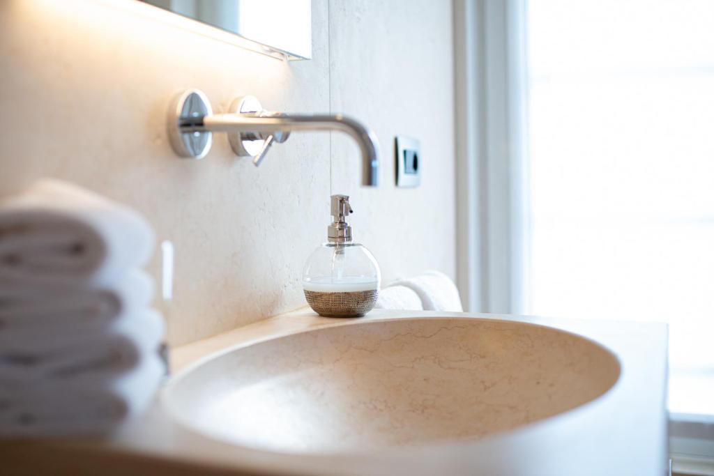 a bathroom sink with a soap dispenser on it at Il Leccio - Luxury Resort Portofino Monte in Santa Margherita Ligure
