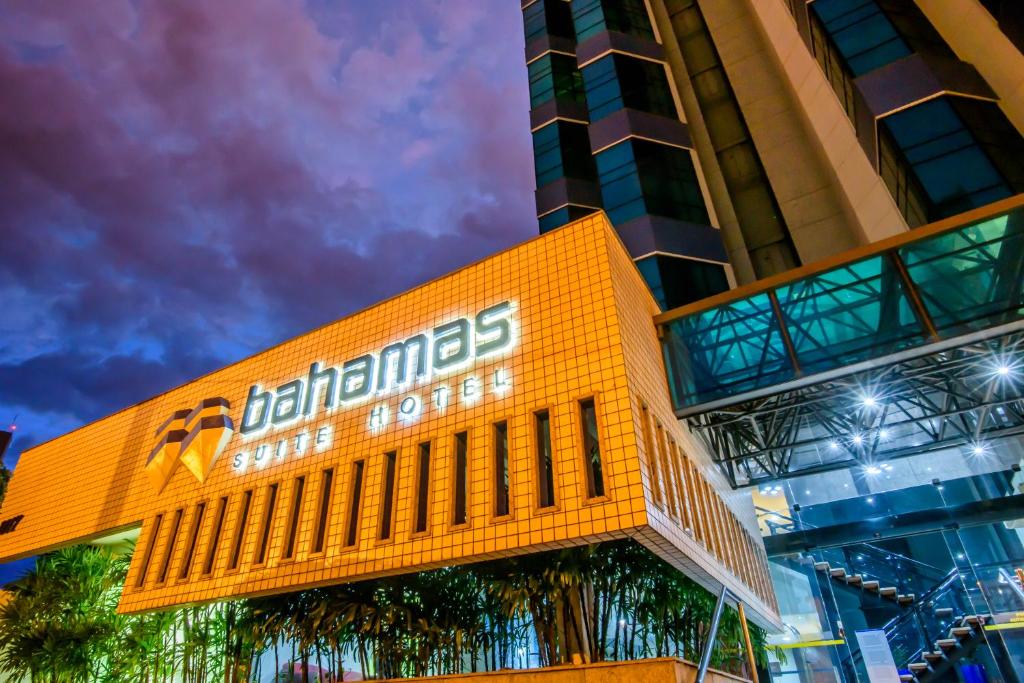 um edifício com um sinal na lateral em Bahamas Suíte Hotel em Campo Grande