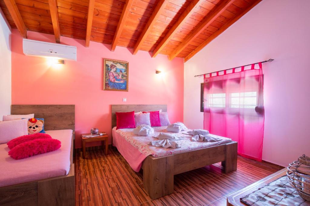een slaapkamer met 2 bedden en roze muren bij Stergios villa in Kolimbia