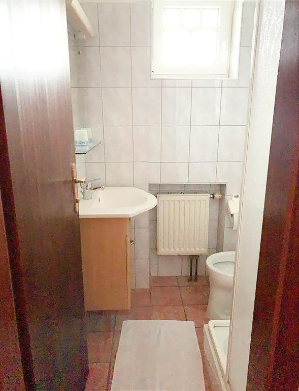 a small bathroom with a sink and a toilet at Pension Huber in Klosterneuburg