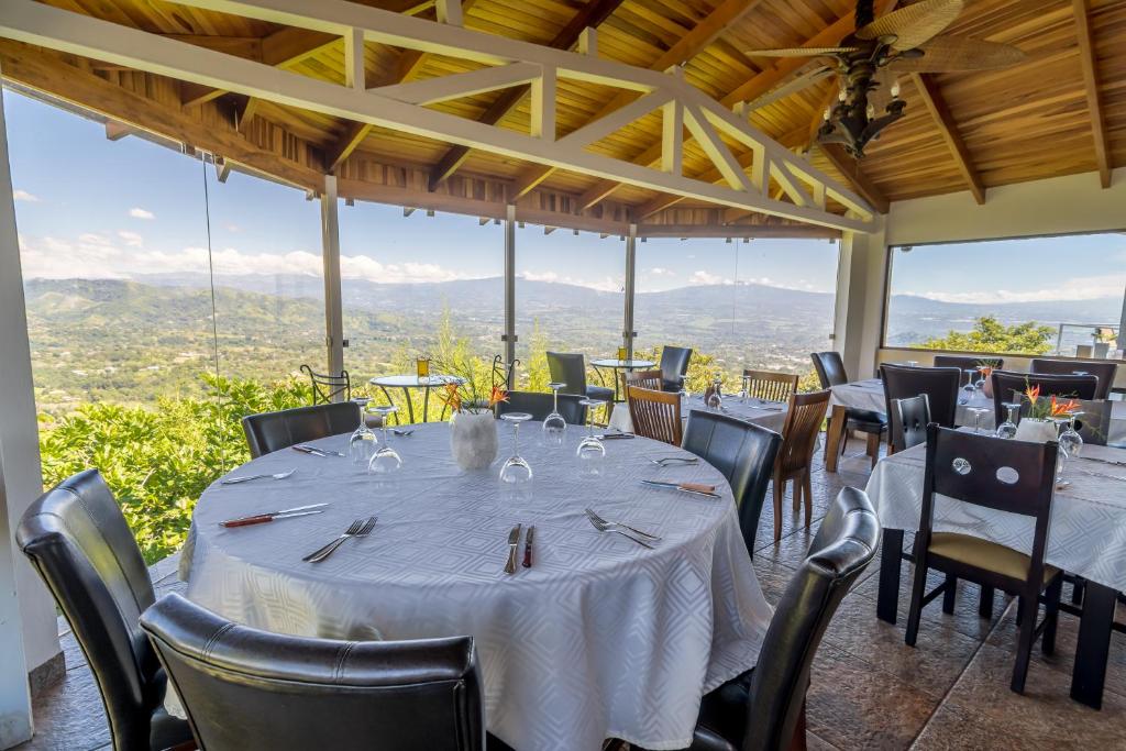 a dining room with a table and chairs with a view at Barons Resort in Atenas