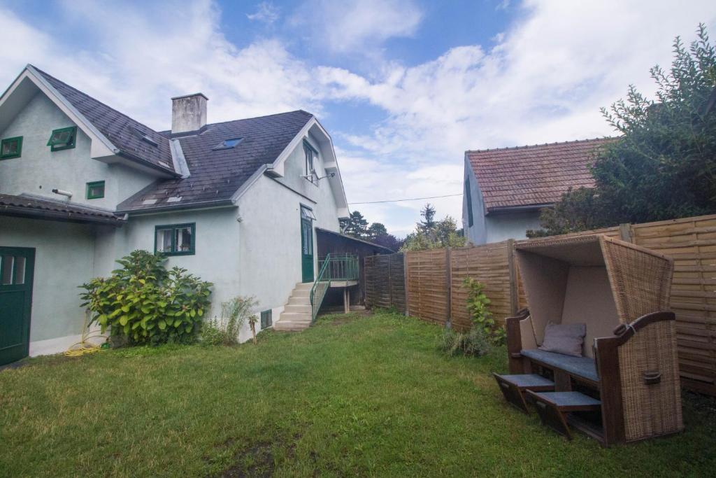 einen Hinterhof mit einem Zaun und einem weißen Haus in der Unterkunft Villa Nina in Orth an der Donau