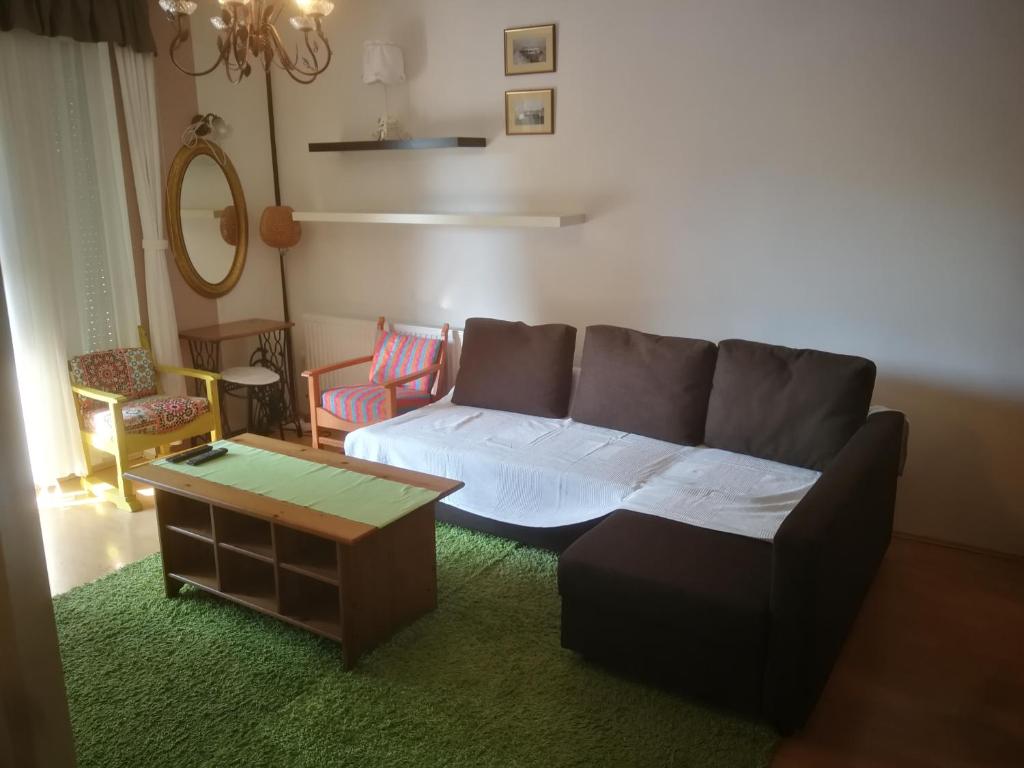 - un salon avec un canapé et une table dans l'établissement Promenade Apartman, à Balatonlelle
