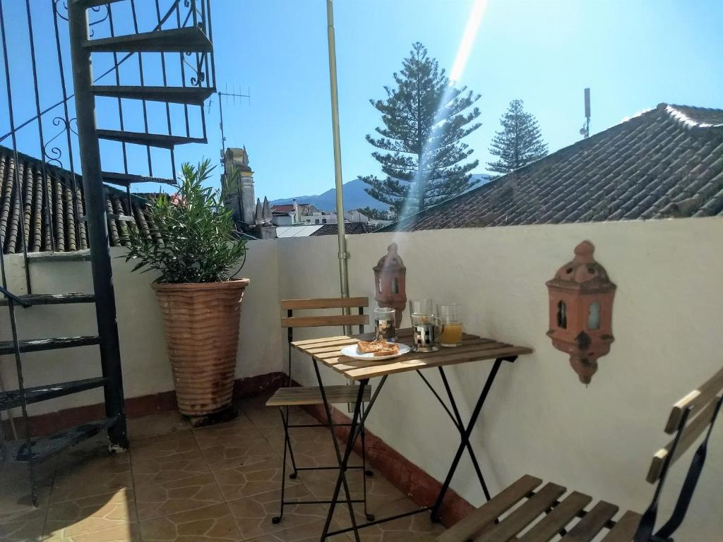 a table and chairs on a patio with a window at Casa Libertad in Órgiva