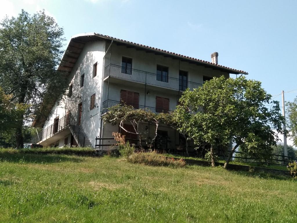 an old house on a hill with a grass field at La Casa nel Verde in Alice Superiore