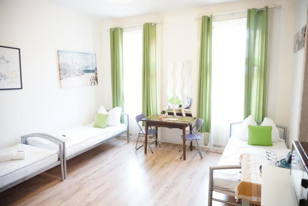 ein Wohnzimmer mit 2 Betten und einem Tisch in der Unterkunft Contactless Check-In Room4You Währing in Wien