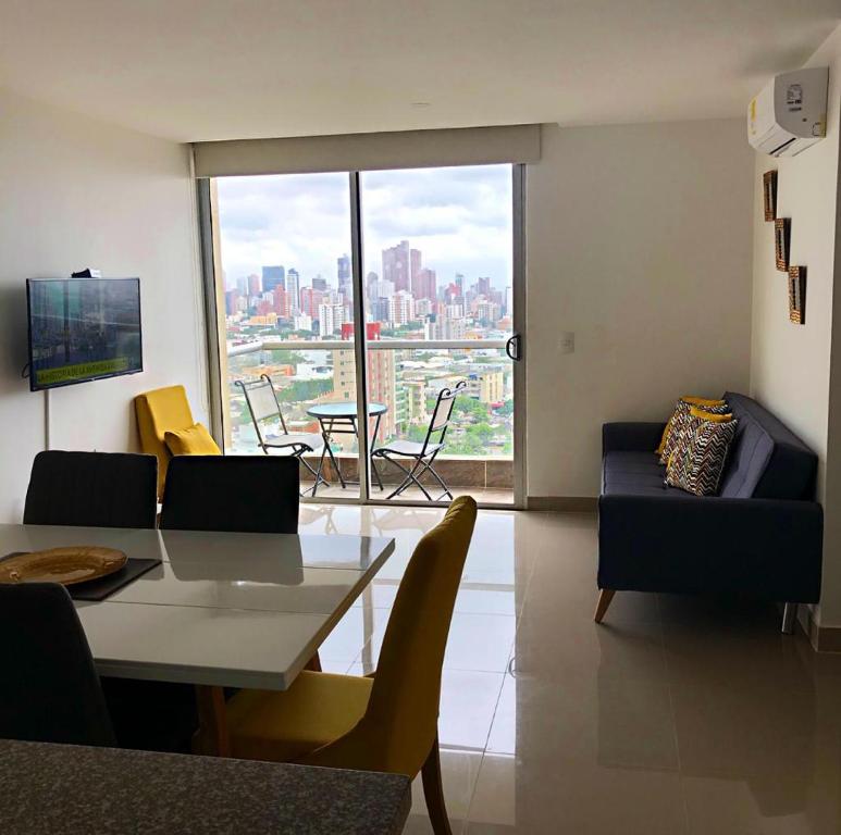 a living room with a couch and a table and a window at Apartamento Panoramico Milano in Barranquilla