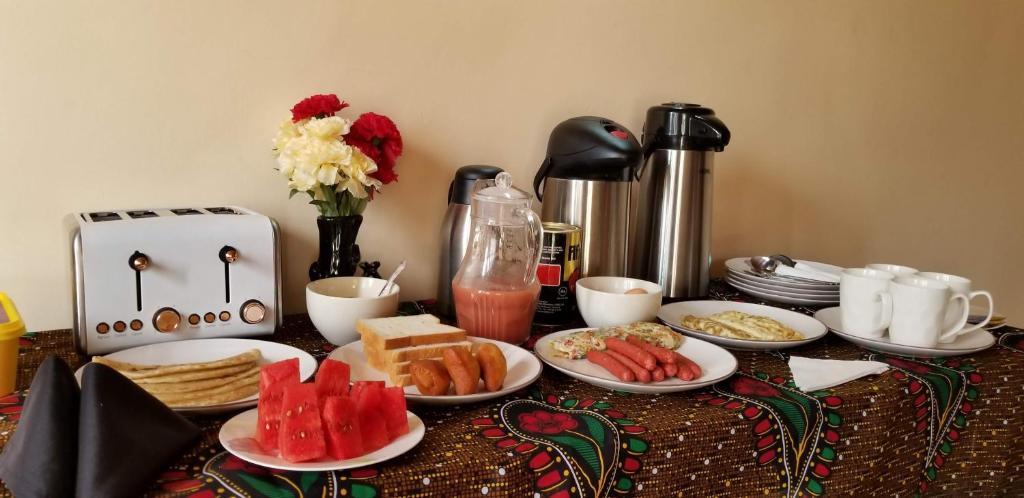 MsarangaにあるAivlys Lodge Kilimanjaroのテーブルの上に食べ物の皿が置かれたテーブル