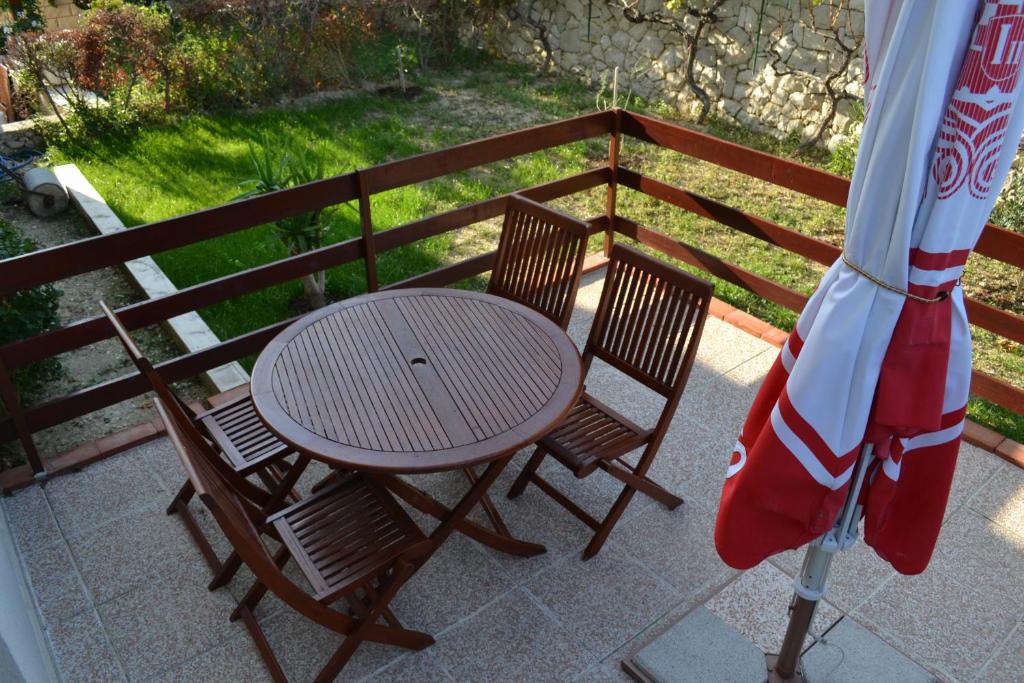 een tafel en twee stoelen en een parasol op een balkon bij Apartments Karlo in Omiš
