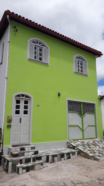 a green house with two windows and a door at Na Brisa TEMPORADA in Mucugê