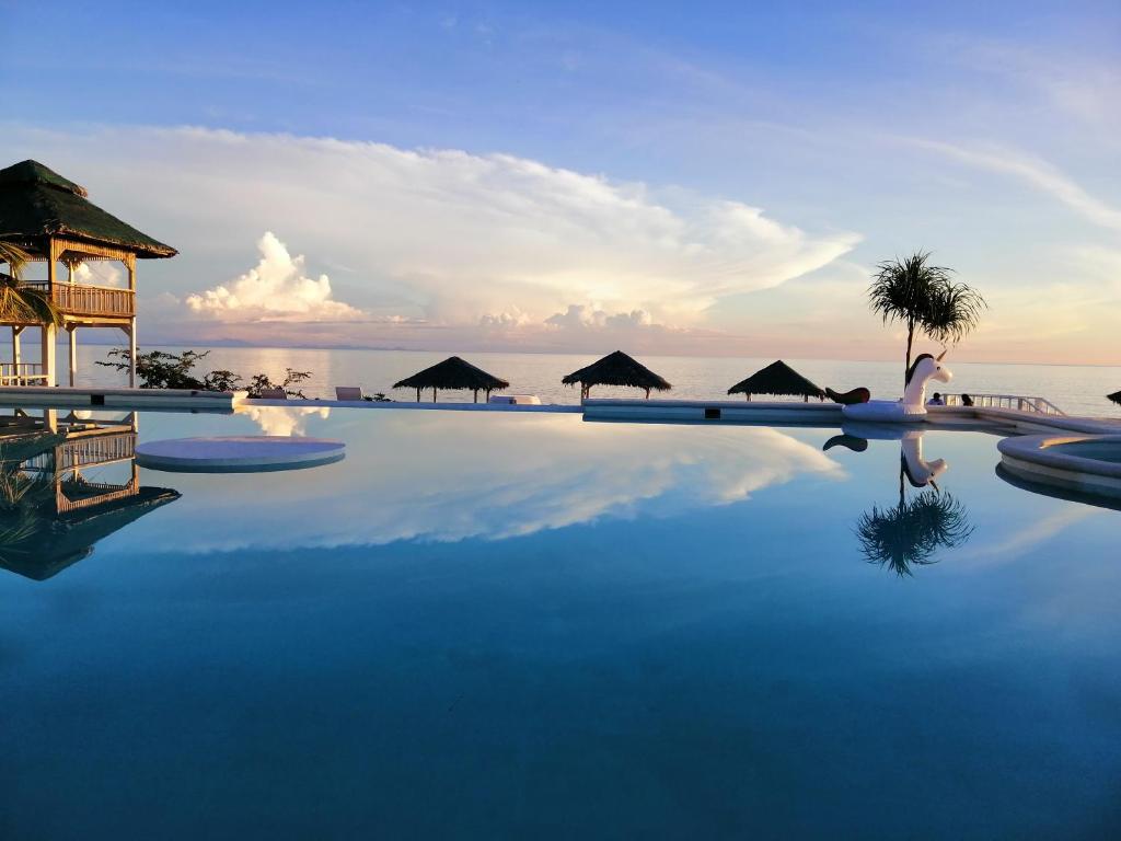 ein Pool in einem Resort mit dem Meer im Hintergrund in der Unterkunft Siquijor Eastern Garan Seaview Resort in Siquijor