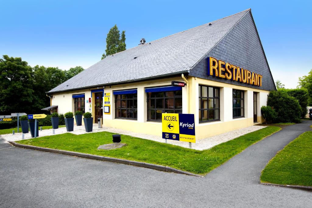 ein gelbes Gebäude mit einem Schild, das Restaurant liest in der Unterkunft Kyriad Angers Sud Ponts-De-Cé in Les Ponts-de-Cé