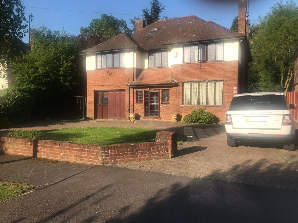 a car parked in front of a brick house at Beautiful mansion in private gated Rd Hot tub FREE SAUNA in Luton