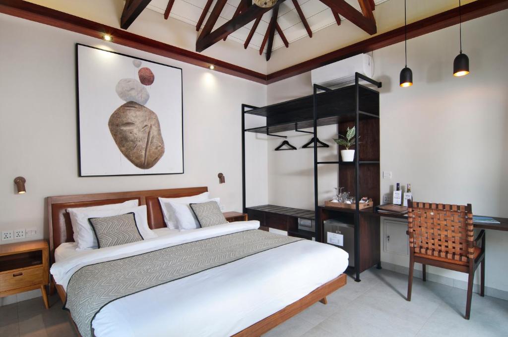 a bedroom with a large bed and a desk at Ke Rensia Private Pool Villas Gili Air in Gili Air