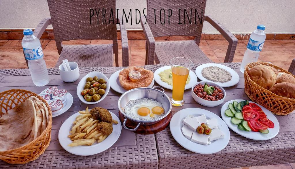 a table with plates of food and drinks on it at Pyramids Top Inn in Cairo